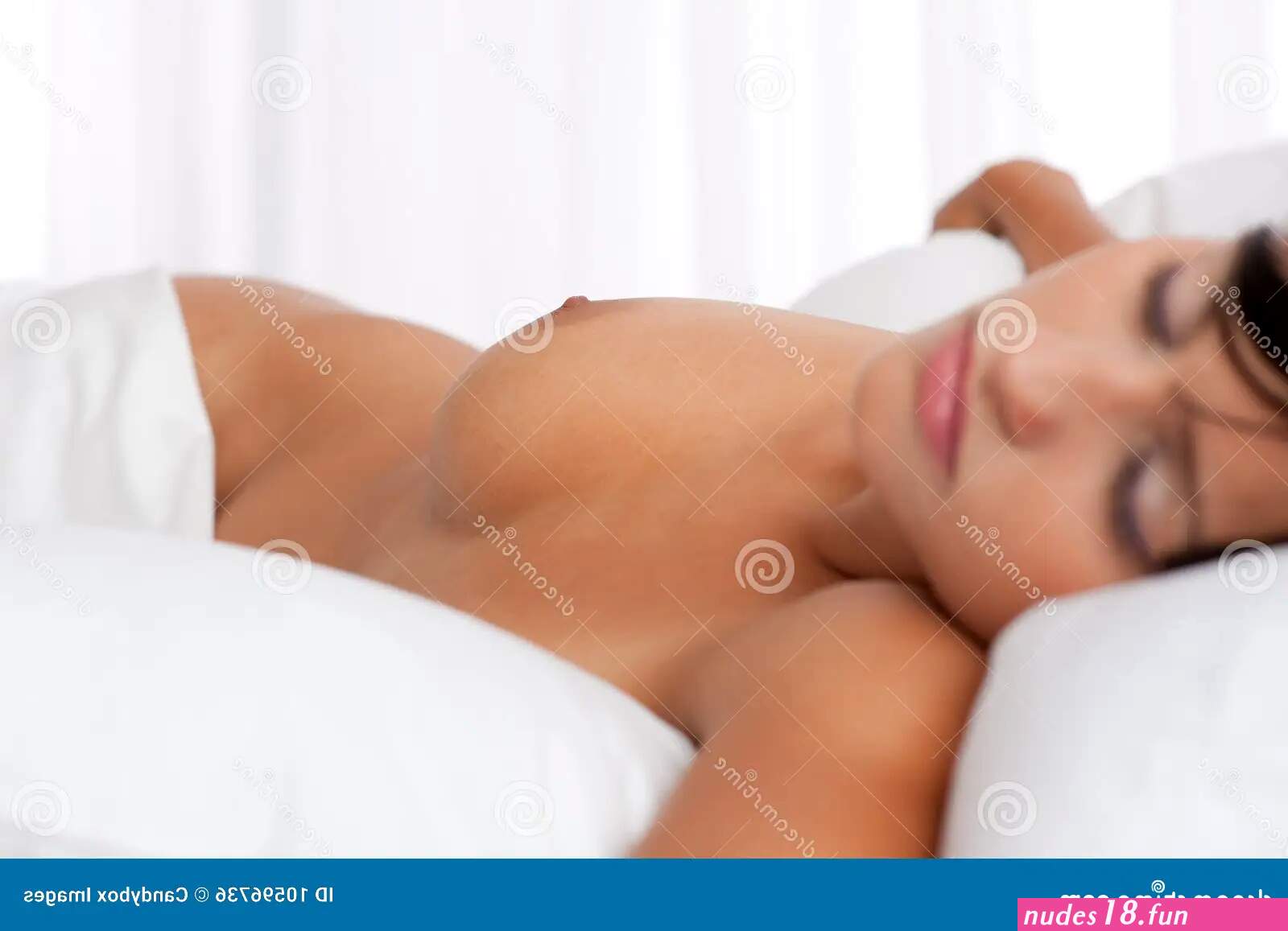 Young Woman Sleeping Naked in White Bed Stock Photo