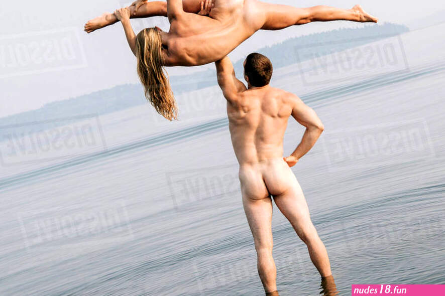 Rear view of nude man lifting nude woman doing the splits