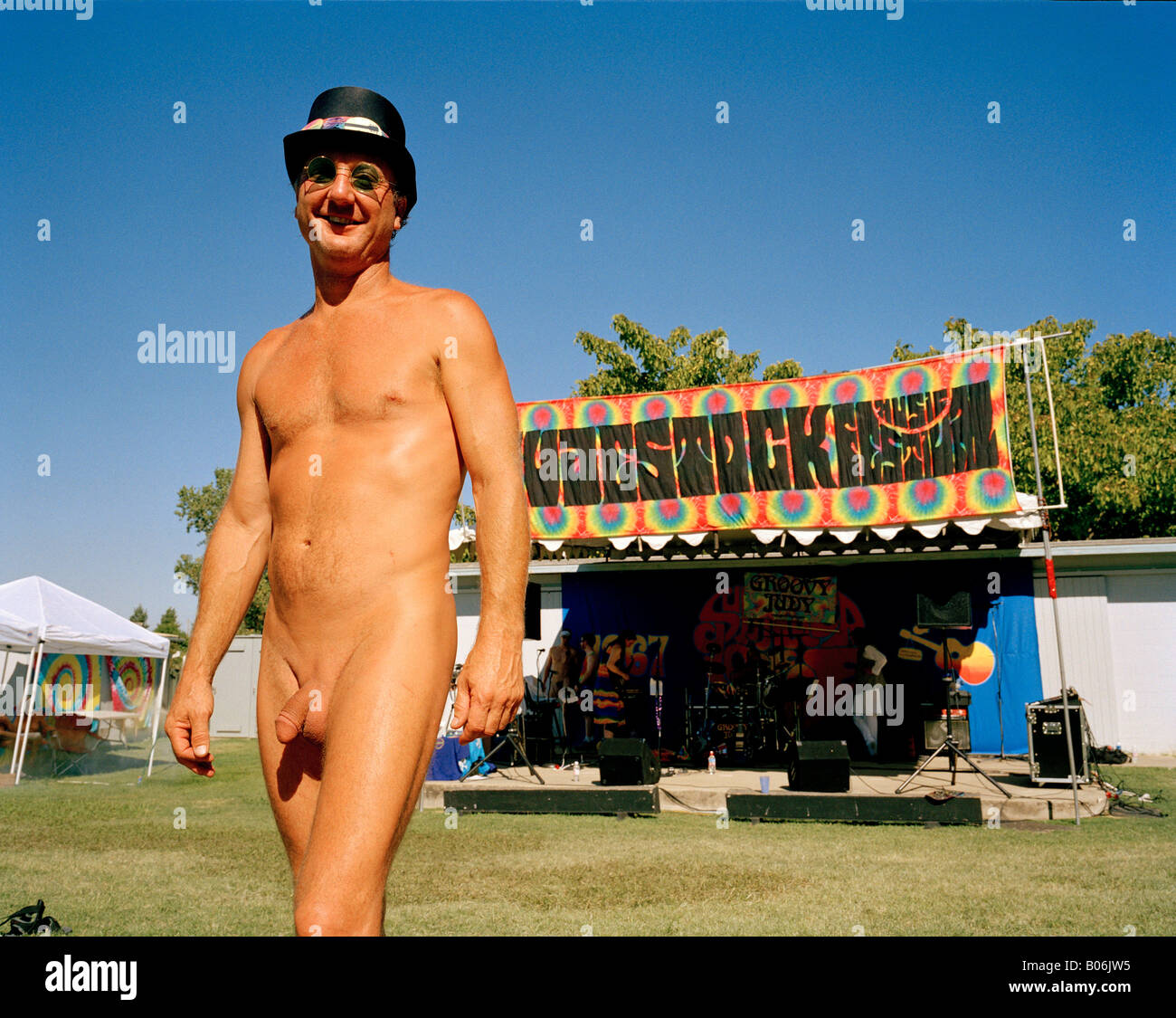 A naked man in a top hat at a music festival Stock Photo
