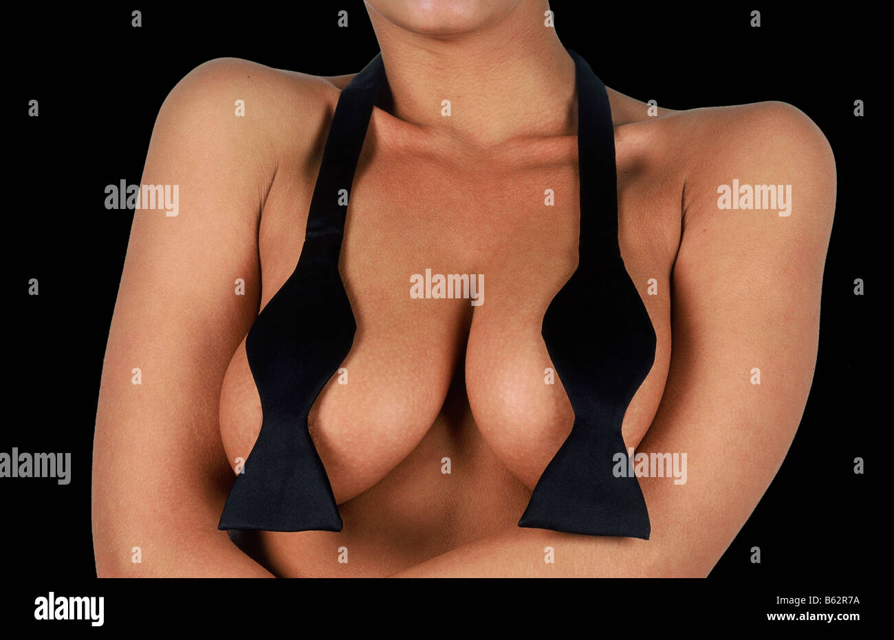 young woman wearing only a bow tie over her naked breasts curvaceous Stock Photo