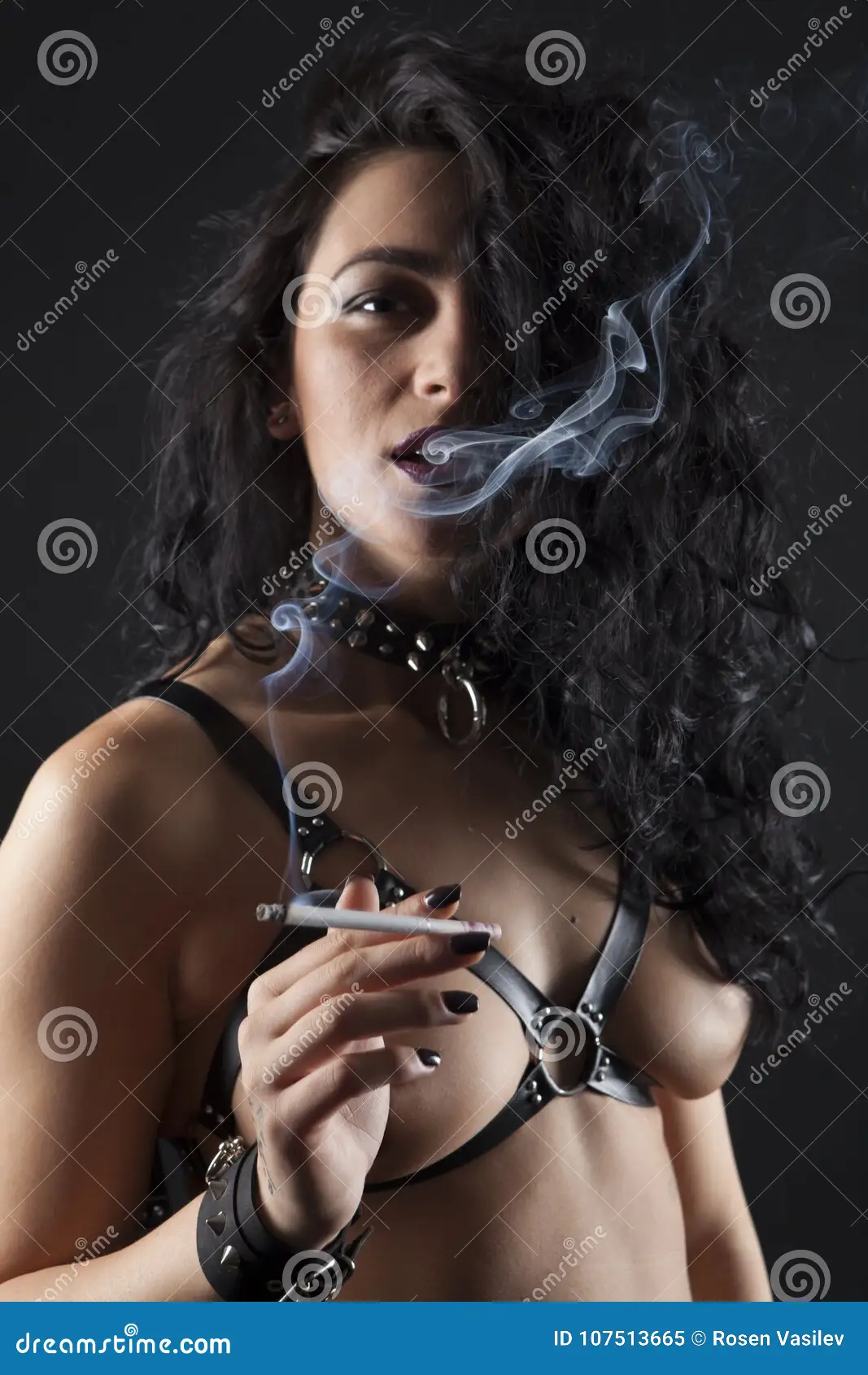 Topless Brunette in Fetish Straps Smoking Cigar. Stock Image