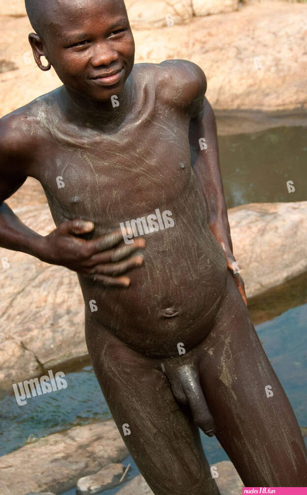 A Suri Surma naked young man body painting himself with mud Ethiopia Stock Photo