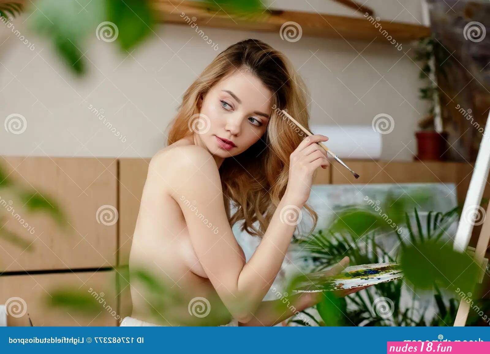Selective Focus of Naked Young Female Painter Holding Brush with Palette and Looking Away Stock Image